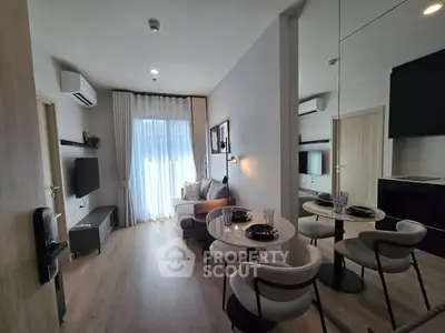 Modern living room with stylish decor and natural light, featuring a cozy seating area and dining space.