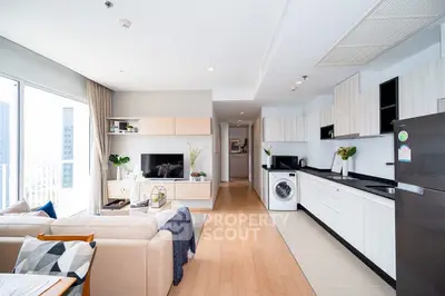 Modern open-layout living room and kitchen with sleek design and natural light