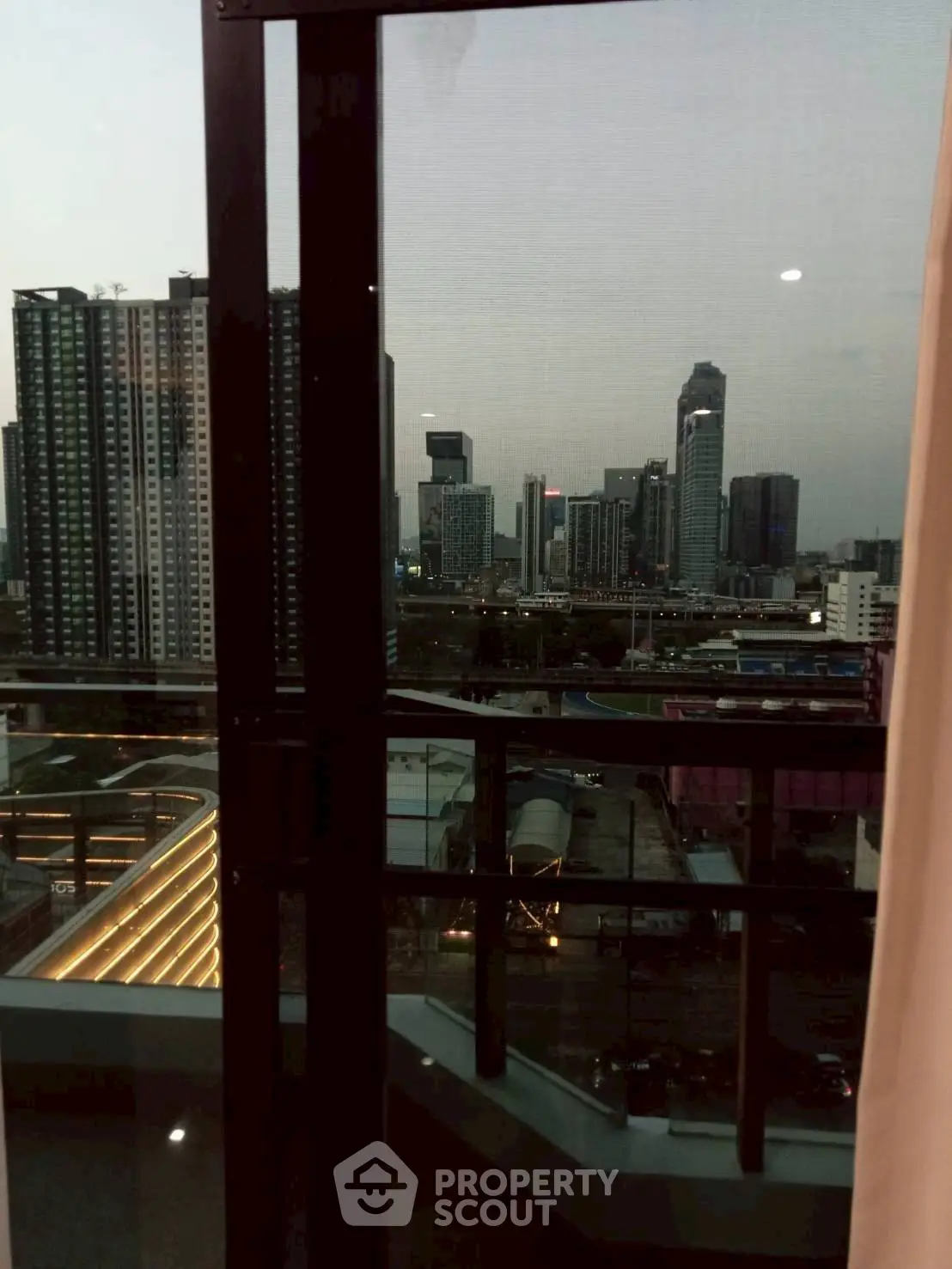Stunning cityscape view from high-rise balcony at dusk, perfect urban living.