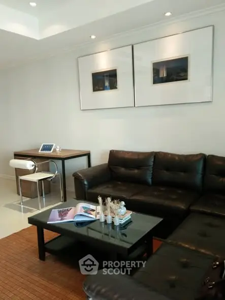 Modern living room with black leather sofa and stylish decor