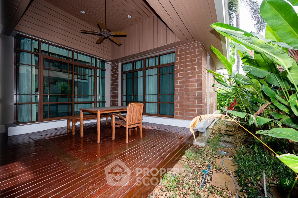 Charming outdoor patio with wooden deck and lush garden view, perfect for relaxation and entertaining.