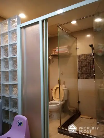 Compact bathroom with glass shower enclosure and modern fixtures, offering a functional and space-efficient interior design.