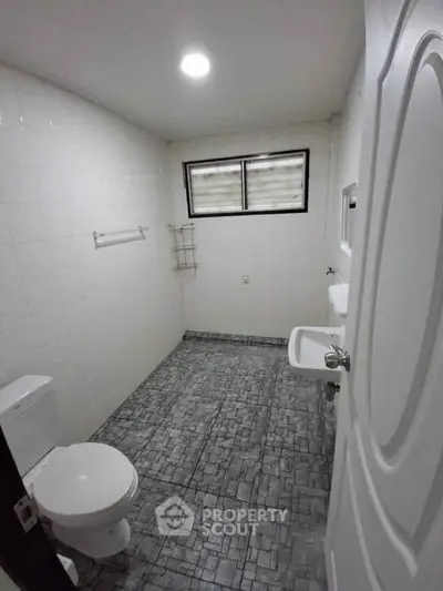 Spacious bathroom with modern fixtures and tiled flooring, ideal for comfort and style.