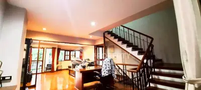 Spacious living room with staircase and natural light, perfect for family gatherings.
