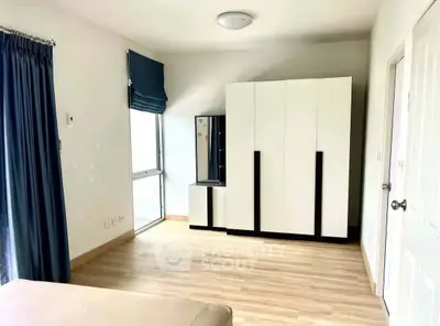 Spacious bedroom with modern wardrobe and natural light in a stylish apartment.