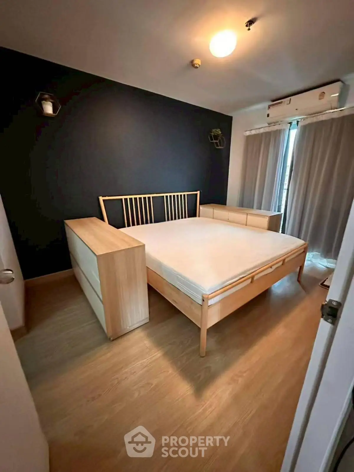 Cozy bedroom with modern wooden furniture and soft lighting, perfect for relaxation and comfort.
