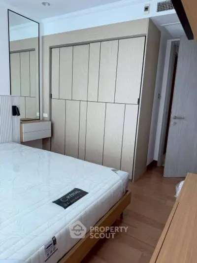 Modern bedroom with sleek wardrobe and wooden flooring