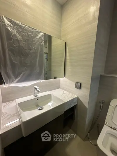 Modern bathroom with sleek sink and mirror in contemporary design.