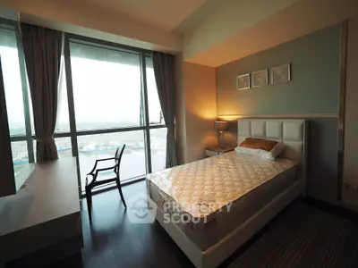 Modern bedroom with large window offering stunning city view, featuring sleek furniture and stylish decor.
