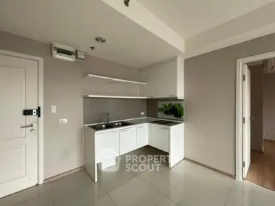 Modern minimalist kitchen with sleek white cabinets and tiled backsplash.