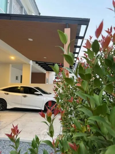 Modern house exterior with sleek carport and lush greenery