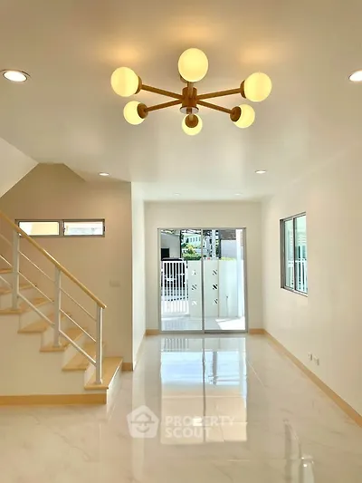 Bright modern living room with elegant lighting and sleek staircase