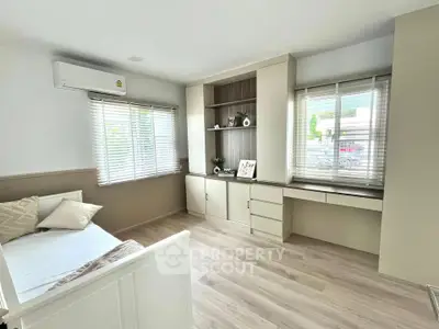 Bright and airy bedroom with built-in storage and large windows.
