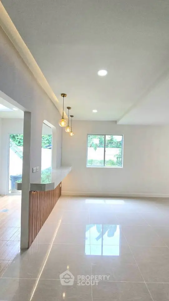 Spacious modern living room with elegant lighting and large windows for natural light.