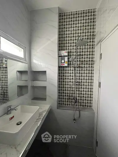 Modern bathroom with elegant marble tiling, walk-in shower featuring a stylish patterned accent wall, and sleek fixtures, perfect for a contemporary home.