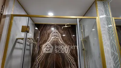 Luxurious bathroom with elegant marble shower and gold fixtures