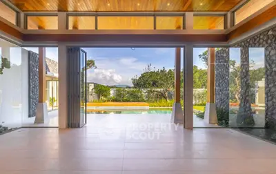 Luxurious open-plan living space with stunning garden and pool view