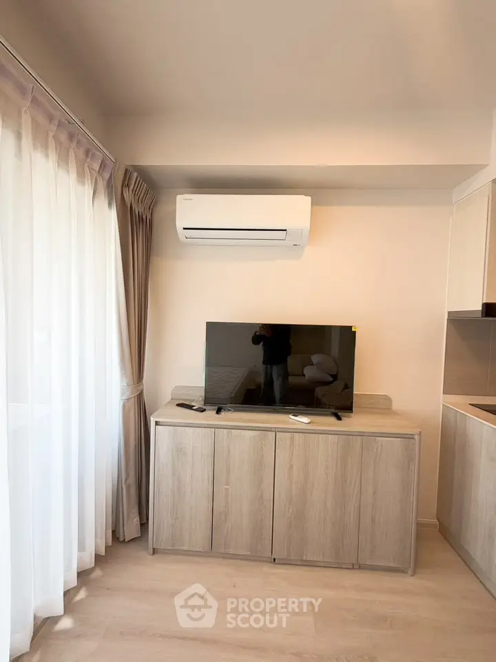Modern living room with air conditioning and sleek TV setup, perfect for cozy relaxation.