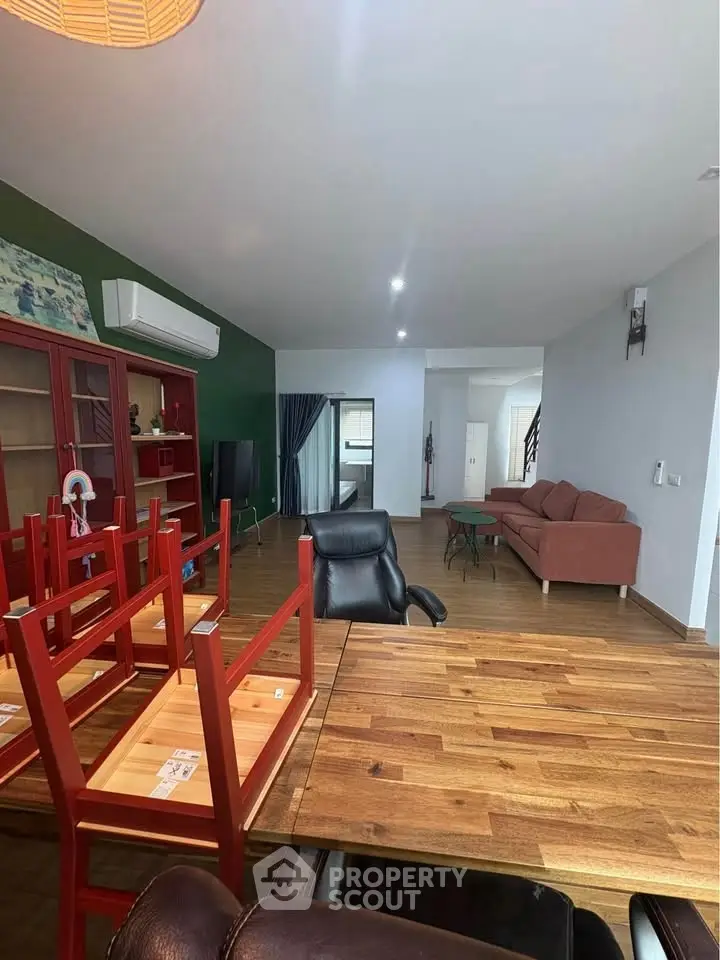 Spacious living room with modern furniture and wooden flooring, ideal for family gatherings.