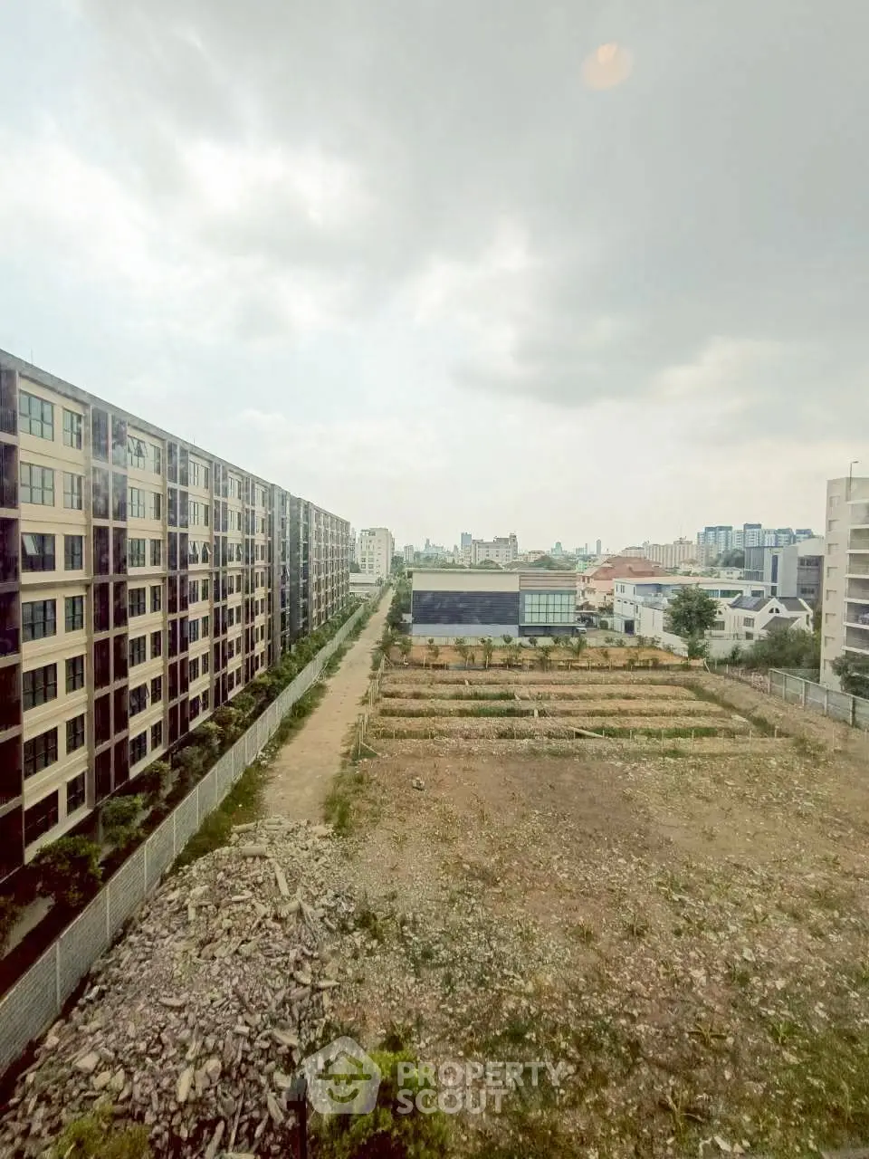Urban landscape view with residential buildings and open land, showcasing potential for development.
