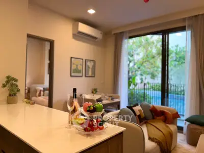 Luxurious living room with pool view, modern decor, and elegant furnishings in a serene setting.