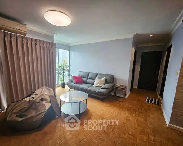 Spacious living room with modern decor and parquet flooring in a cozy apartment.