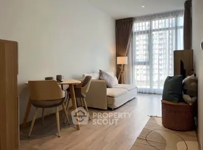 Modern living room with natural light, cozy seating, and stylish dining area in a contemporary apartment.