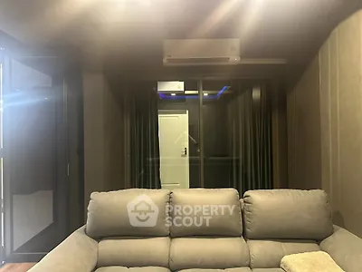 Modern living room with plush sofa and air conditioning, featuring a sleek design and cozy ambiance.
