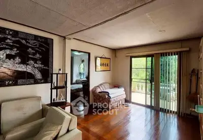 Cozy living room with wooden flooring and large window for natural light