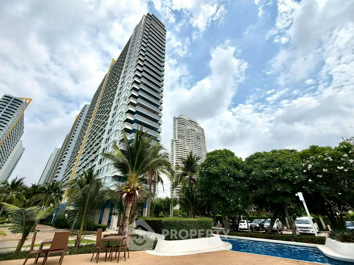 Luxurious high-rise buildings with lush gardens and poolside seating in a prime urban location.