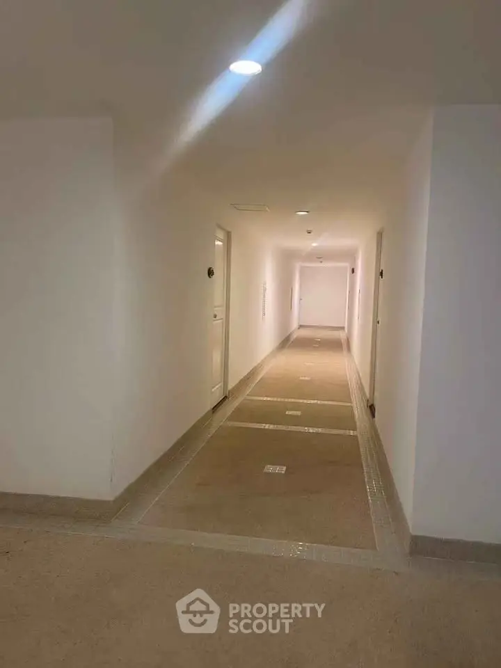 Modern apartment building corridor with clean design and bright lighting.