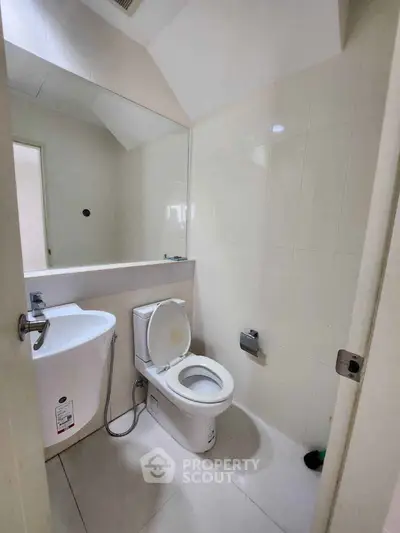 Modern bathroom with sleek fixtures and large mirror in a contemporary apartment.