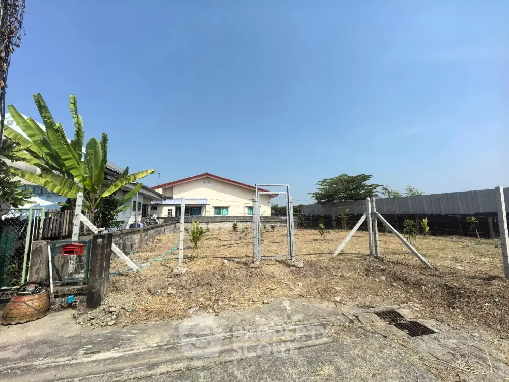 Spacious residential plot with fencing and clear blue sky, ideal for building your dream home.