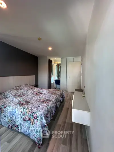 Spacious bedroom with floral bedding and modern decor in a stylish apartment