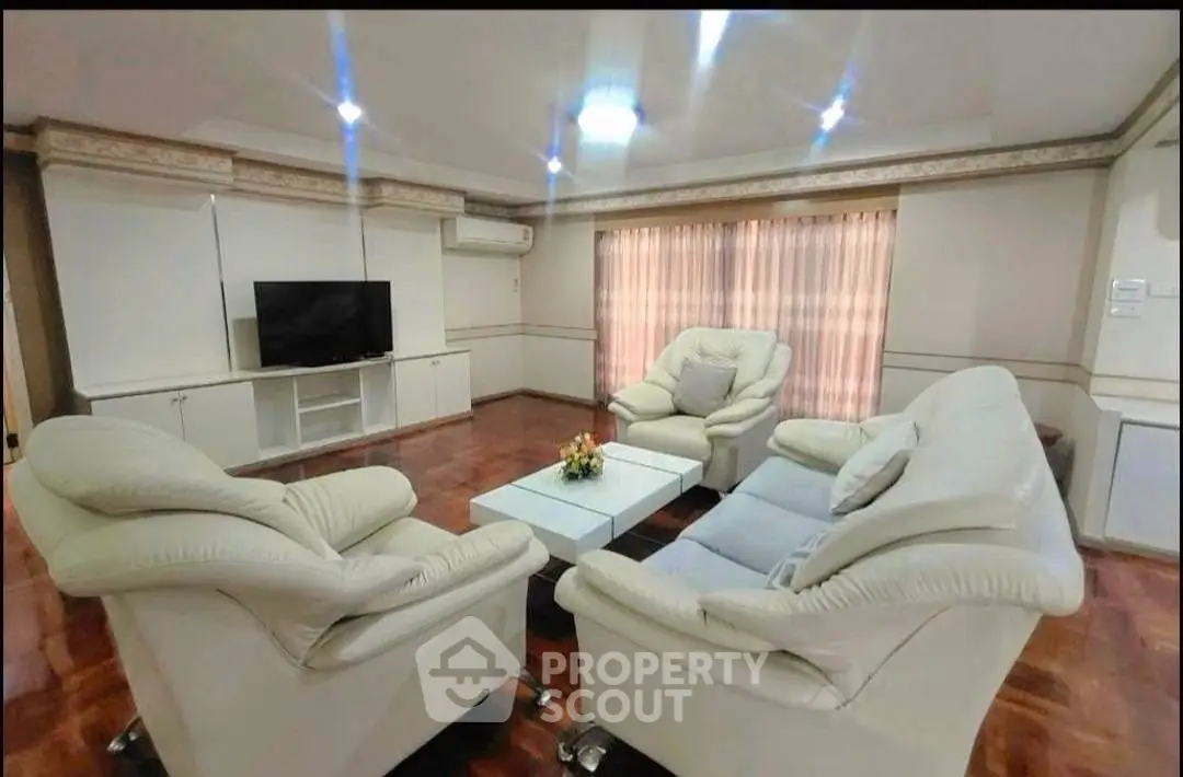 Spacious living room with elegant white leather sofas and modern decor