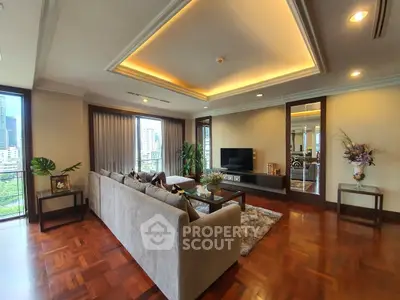 Luxurious living room with elegant decor and city view, featuring a spacious sofa and modern entertainment center.