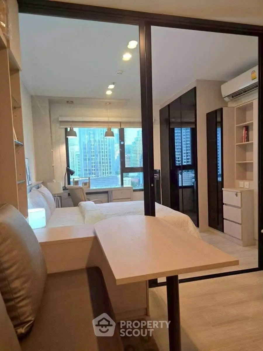 Modern studio apartment with city view, featuring cozy living area and sleek design.