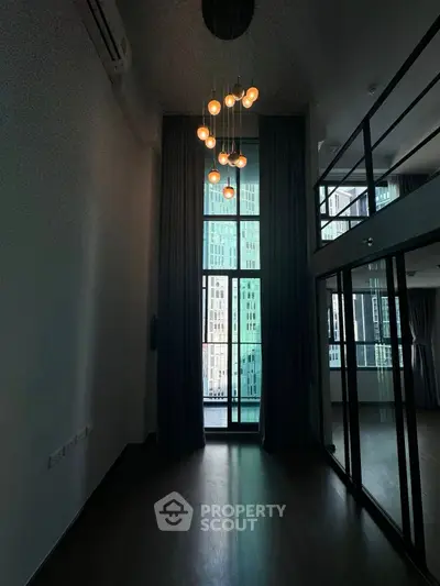 Modern loft apartment with high ceilings and large windows offering city views.