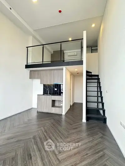 Modern loft apartment with mezzanine, sleek staircase, and stylish wood flooring.