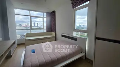 Modern bedroom with large windows offering stunning city views