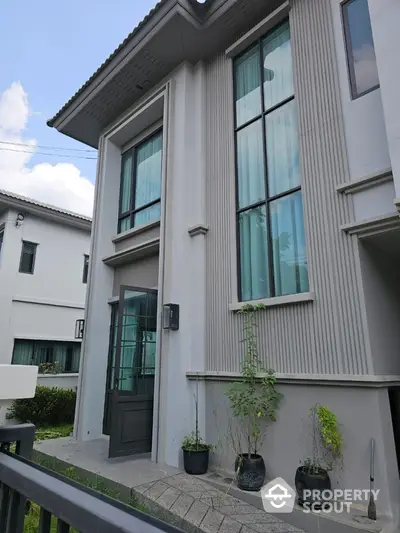 Modern two-story house exterior with large windows and elegant facade