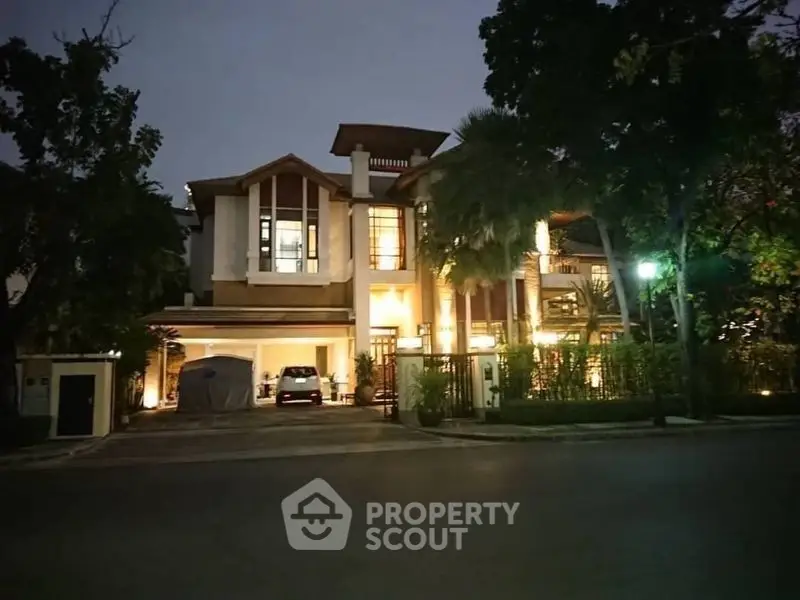 Luxurious modern house with elegant exterior lighting and lush greenery at dusk.
