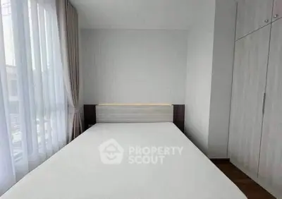 Modern minimalist bedroom with large window and built-in wardrobe