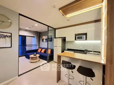 Modern open-layout kitchen and living room with stylish decor and balcony view.