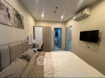 Cozy bedroom with modern decor and ensuite bathroom, featuring a wall-mounted TV and air conditioning.