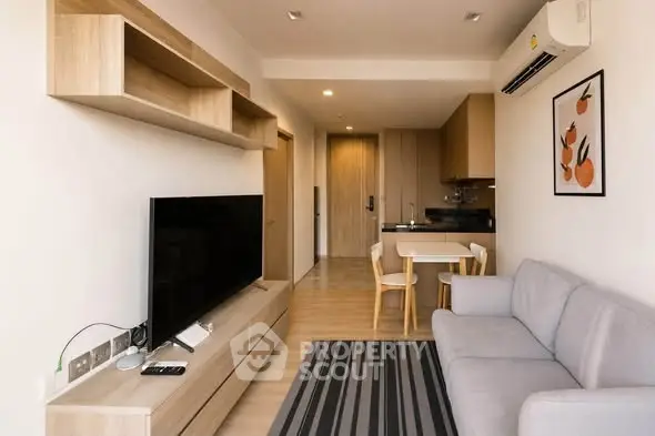 Modern living room with sleek furniture and open kitchen layout in a stylish apartment.
