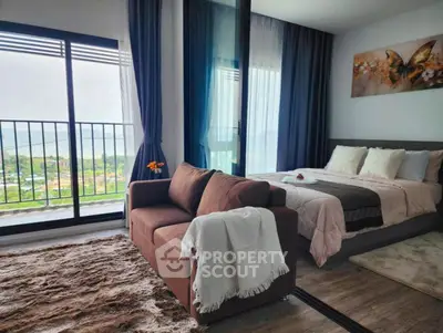 Stylish bedroom with cozy seating and scenic balcony view