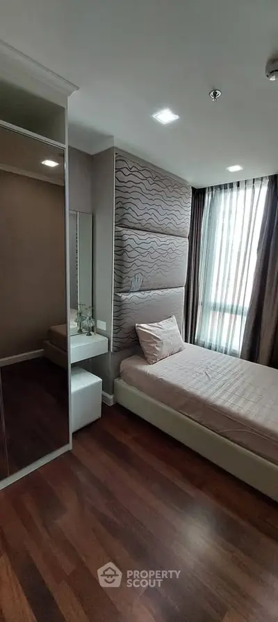 Modern bedroom with stylish decor and large window for natural light