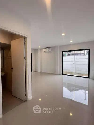 Spacious modern living room with large windows and sleek tile flooring