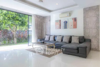 Spacious living room with modern decor and garden view, featuring a large sectional sofa and elegant artwork.